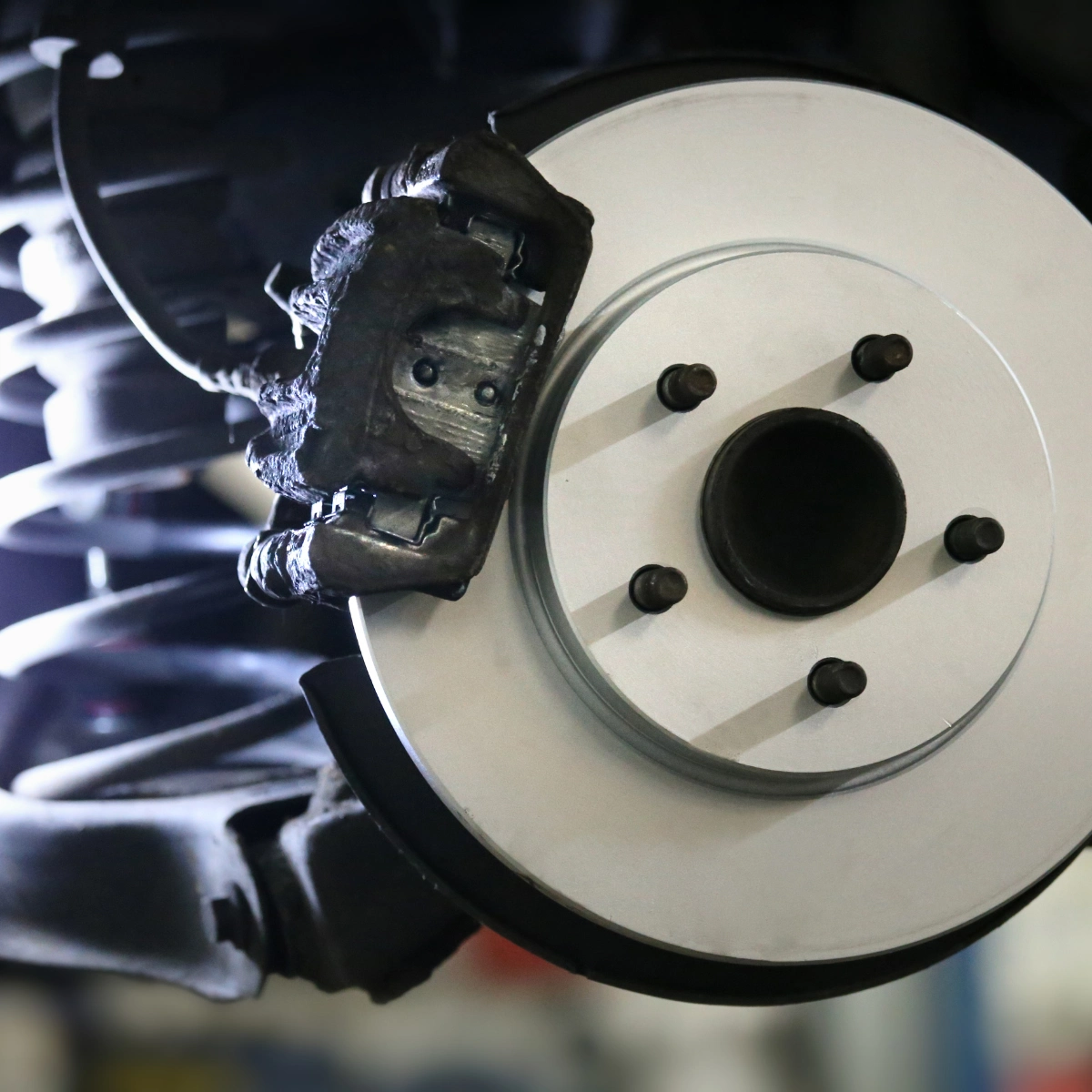 Technician inspecting vehicle brakes and wheels