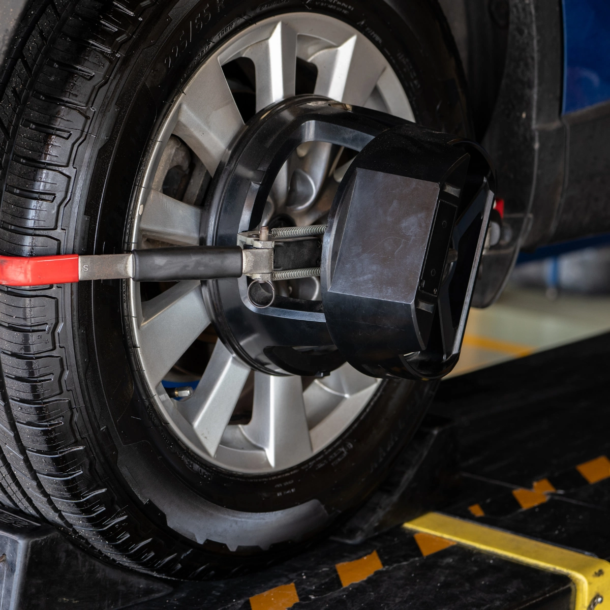 Technician setting up computerized wheel alignment sensors